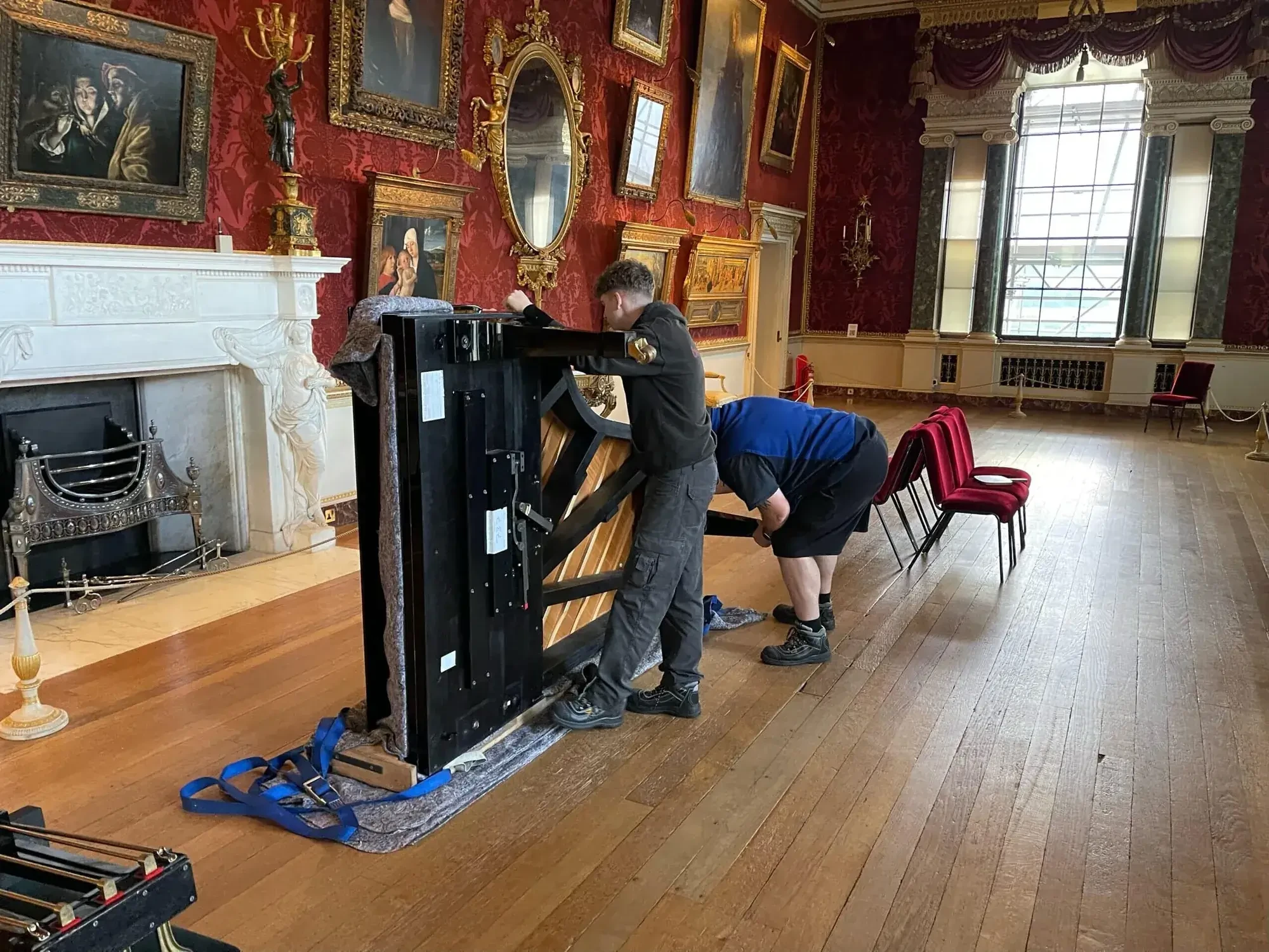 Grand piano being moved by the Piano Removal Leeds team inside a grand Leeds interior