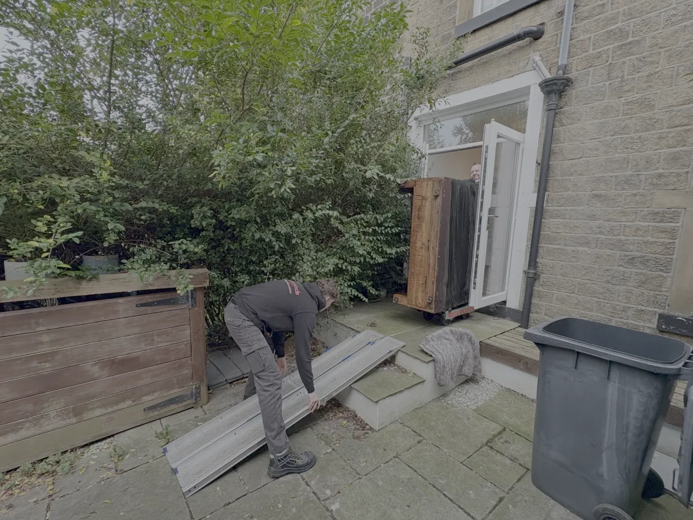 Old upright piano being removed for recycling in Yorkshire